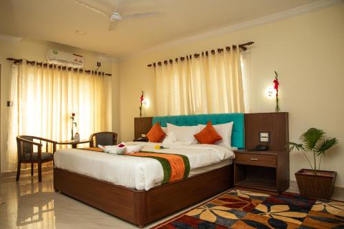 拜拉哈瓦Gautam Buddha Airport Hotel的一间卧室配有一张大床和一张桌子及椅子