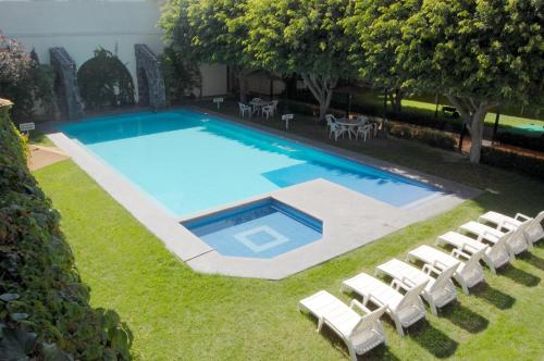 圣路易斯波托西Real de Minas San Luis Potosi的享有带白色躺椅的游泳池的顶部景致