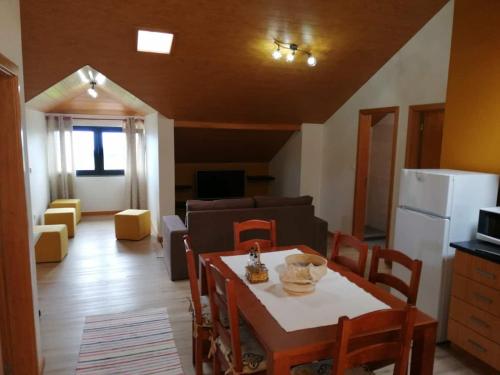 莫尼兹港Recantos do Castanheiro的厨房以及带桌椅的起居室。