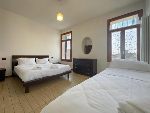 孔塞尔韦Blue Apartment Conselve的一间卧室配有两张床和镜子