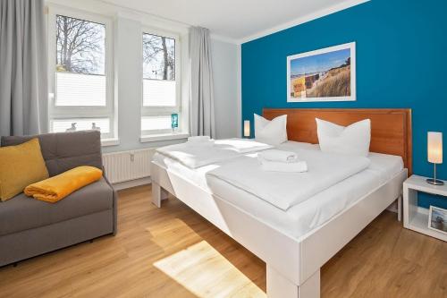 黑灵斯多夫Strand-Park Strand-Park 204的卧室配有一张白色的大床和一张沙发。