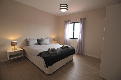 卡列塔Pedreira apartment的一间卧室设有一张大床和一个窗户。