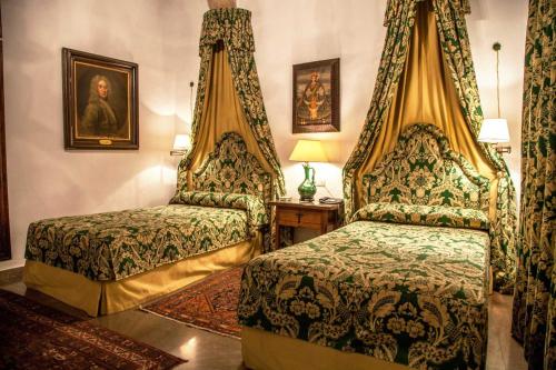 特鲁希略奥雷利亚纳精品之家酒店的一间卧室设有两张床,墙上挂着一幅画