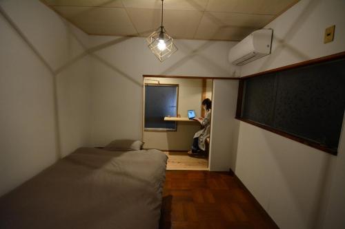 三岛市Guesthouse giwa - Vacation STAY 14271v的一间设有两张床的房间和一个手提电脑上的人