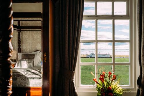 莱瑟姆-圣安妮The Queens Hotel的享有床和田野景致的窗户