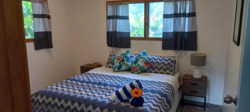拉罗汤加Tropical Retreat Rarotonga的卧室配有带枕头的床铺和窗户。