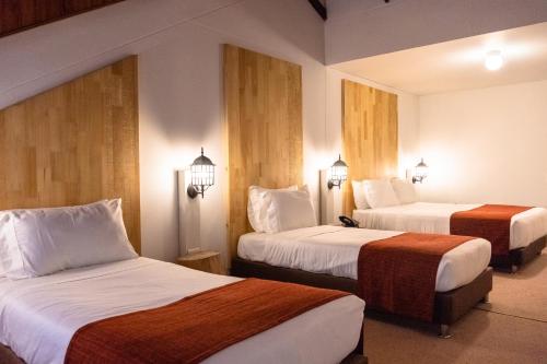 圣罗莎德卡瓦尔Termales Santa Rosa De Cabal的酒店客房设有两张床和两盏灯。