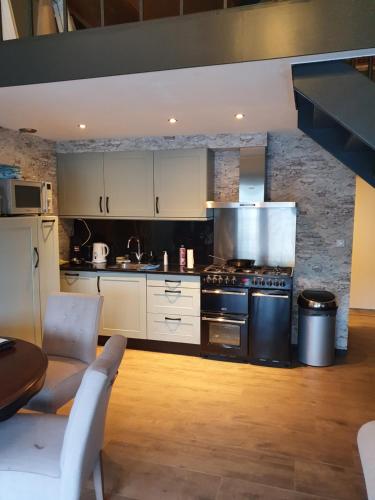 阿姆斯特丹Tjotter的厨房配有白色橱柜和炉灶烤箱。