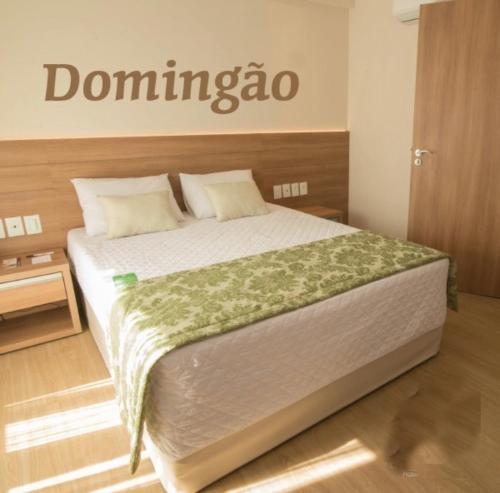 佩德拉阿祖尔Cond Vista Azul的卧室配有一张挂有墙上标志的床