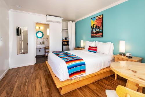 圣巴巴拉龙舌兰汽车旅馆的一间卧室配有一张大床和一张桌子