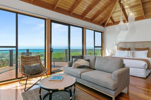阿波罗湾Point of View Villas的一间卧室配有一张床、一张沙发和一张桌子