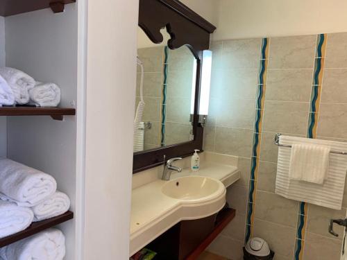 圣吕斯Appartement terrasse vue mer dans village Pierre Vacances的浴室配有盥洗盆、镜子和毛巾