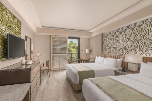 长滩岛Henann Park Resort的酒店客房设有两张床和电视。