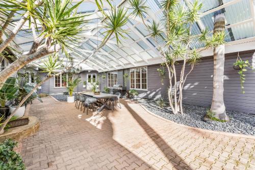 亚林加普雅林角Spa山林小屋的一个带桌椅和棕榈树的庭院