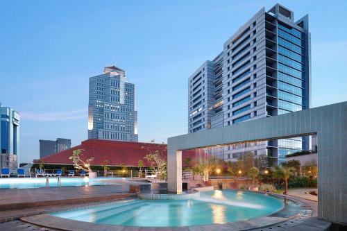 雅加达Hotel Bidakara Jakarta的一座位于城市中心,拥有高楼建筑的游泳池