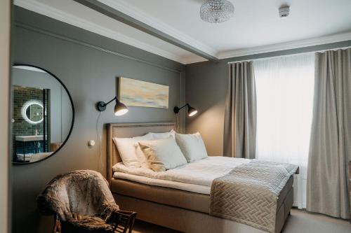 坦佩雷Lillan Hotel & Kök的一间卧室配有一张带镜子的床和窗户