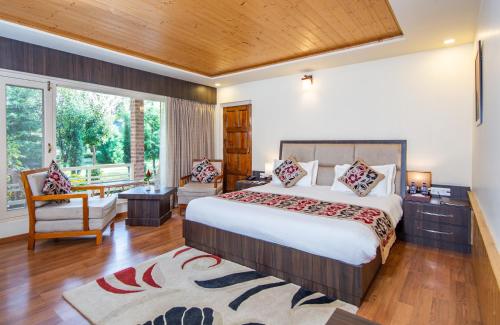 斯利那加The Orchard Retreat & Spa的一间卧室设有一张大床和一个大窗户