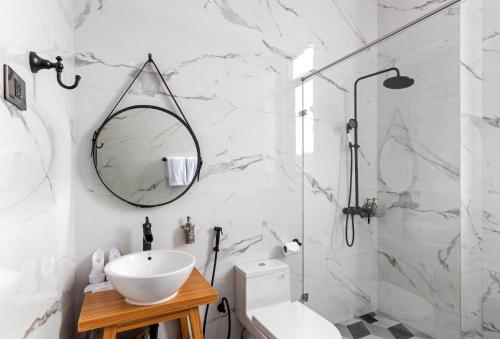 美娜多万鸦老S阁楼酒店的白色的浴室设有水槽和镜子