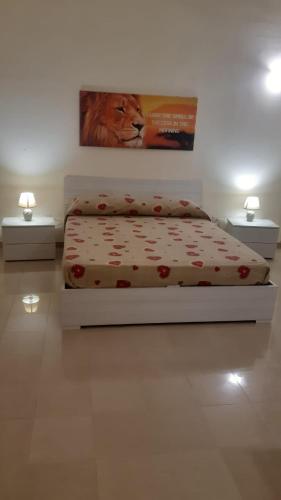 韦列Savina's House 2的卧室配有一张床,还展示了狮子的照片