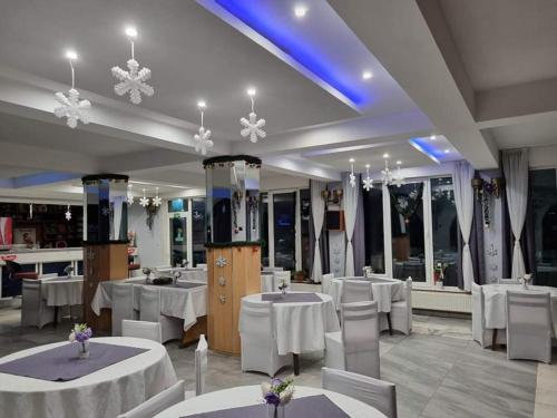 桑丹斯基Motel Thessaloniki的一间设有白色桌椅的用餐室