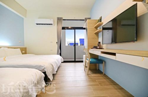 马公澎湖原慕心民宿的酒店客房设有两张床、一张书桌和电视