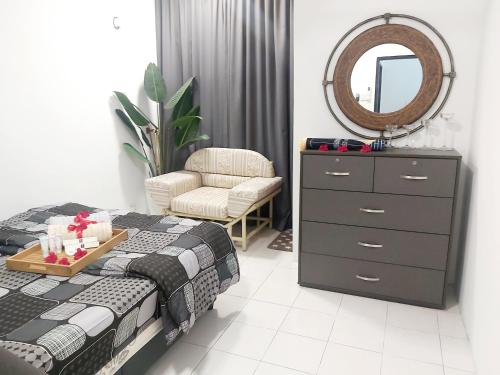 万挠Islamic Homestay Apartment Kundang, Rawang的一间卧室配有一张床、梳妆台和镜子