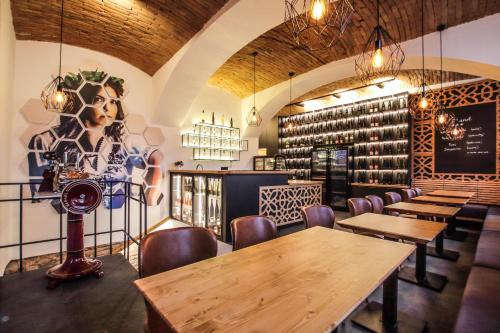 兹诺伊莫Hotel Mariel Znojmo的餐厅设有桌椅和葡萄酒瓶壁