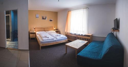 多纳瓦利Penzion Zornicka的一间卧室配有一张床、一张沙发和一张桌子