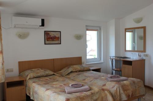 索佐波尔拉迪克酒店的一间卧室配有一张床,上面有两条毛巾