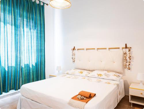 坎波马里诺Campitur的卧室配有白色的床和蓝色窗帘