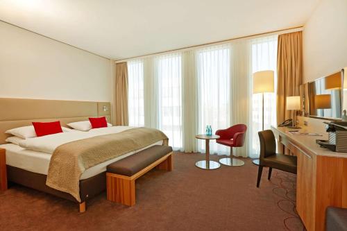 慕尼黑H4慕尼黑展览中心酒店的配有一张床和一张书桌的酒店客房