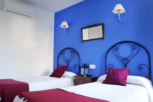 莫哈卡尔阿科广场旅馆的蓝色的客房配有两张床和镜子