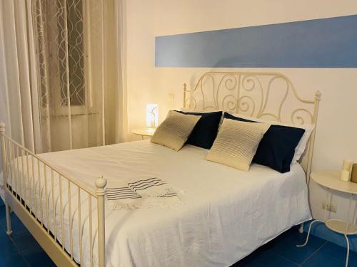 丽都迪奥斯蒂亚Sun&SeaGuestHouse Lido di Roma的卧室内的一张带黑色枕头的白色床