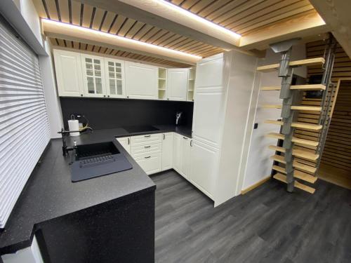 VitanjeBrunarica Rogla的厨房配有白色橱柜和台面上的笔记本电脑