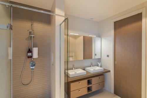 圣马洛Résidence Premium Le Bénétin- Saint Malo的一间带两个盥洗盆和淋浴的浴室