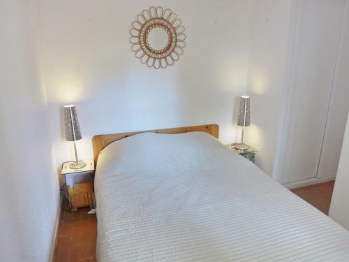 拉卡诺奥肯Holiday Home Les Palombes-7 by Interhome的卧室配有带两盏灯的白色床