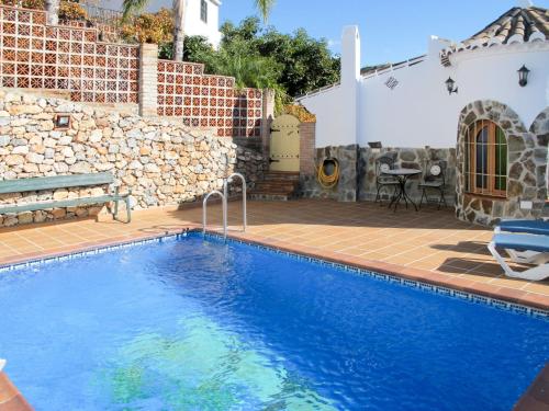 弗里希利亚纳Holiday Home Tres Palmeras - FRG131 by Interhome的一座带石墙的庭院内的游泳池