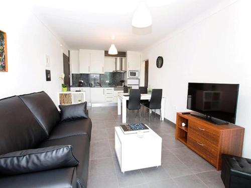 艾姆布里亚布拉瓦Apartment Port Banyuls-4 by Interhome的带沙发和电视的客厅以及厨房。