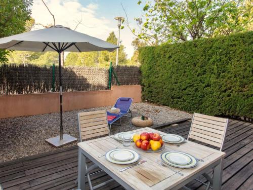 卡拉法特Apartment Marina Sant Jordi by Interhome的一张桌子,上面放着一碗水果和一把雨伞