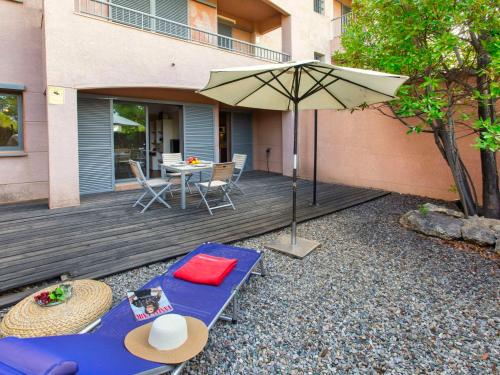 卡拉法特Apartment Marina Sant Jordi by Interhome的一个带桌子和遮阳伞的庭院