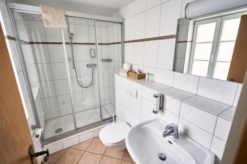温克尔科尔夫宾馆的带淋浴、卫生间和盥洗盆的浴室