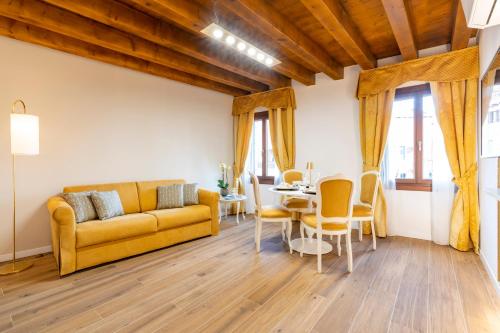 威尼斯Laguna D'oro Luxury Apartments的客厅配有黄色的沙发和桌子