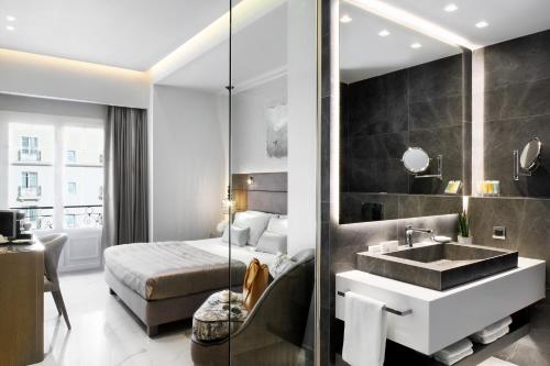 塞萨洛尼基宫殿大酒店的酒店客房设有水槽和一张床