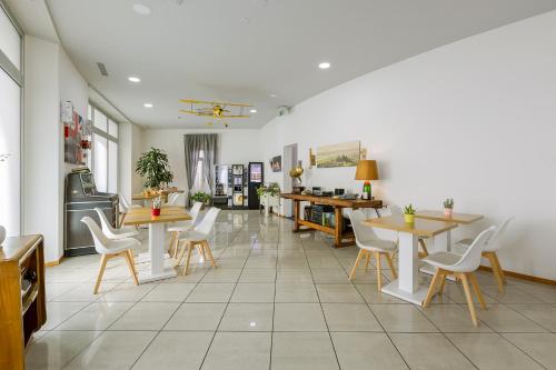 卢加诺GuestHouse Lugano Center by LR的一间带桌子和白色椅子的餐厅和一间房间
