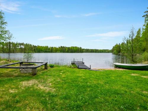 HankamäkiHoliday Home Lehtikuusenranta by Interhome的野餐桌和湖上的小船