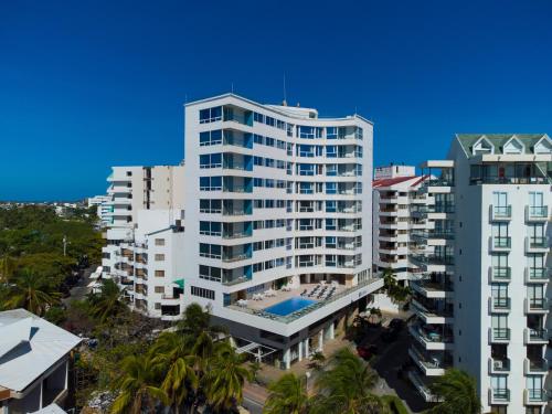 圣安德烈斯Samawi Hotel的一座高大的白色建筑,前面有一个游泳池