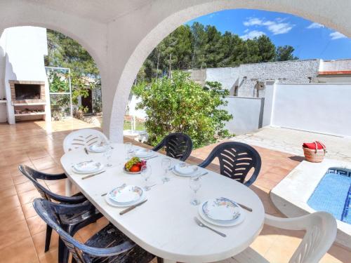 拉梅特拉·德·玛尔Villa Villa Zozo by Interhome的一个带游泳池的庭院内的白色桌椅