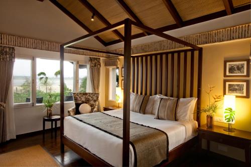 Begūr士乃卡碧尼度假村的一间卧室设有天蓬床和窗户。