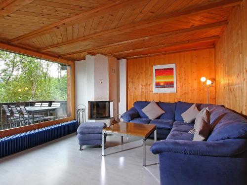 格林德尔瓦尔德格林德瓦艾格伊奇度假屋的客厅配有蓝色的沙发和桌子