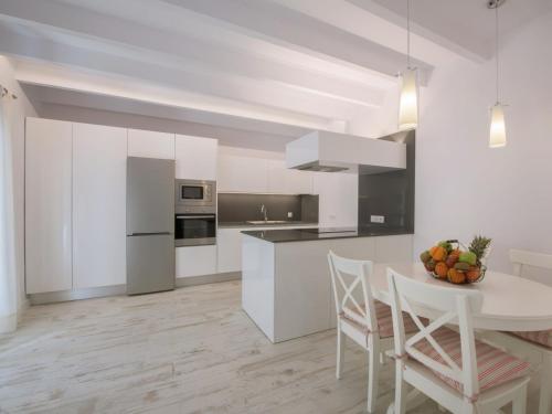 科斯提克斯Holiday Home Es Reco by Interhome的厨房配有白色橱柜和桌椅